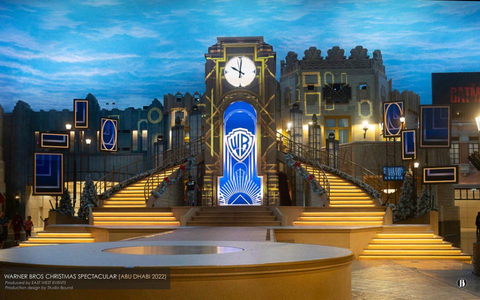 Warner Bros. World Abu Dhabi — central-plaza stage and clock tower designed by Patrick Larsen and Studio Bound for the 2022 Winter Spectacular.